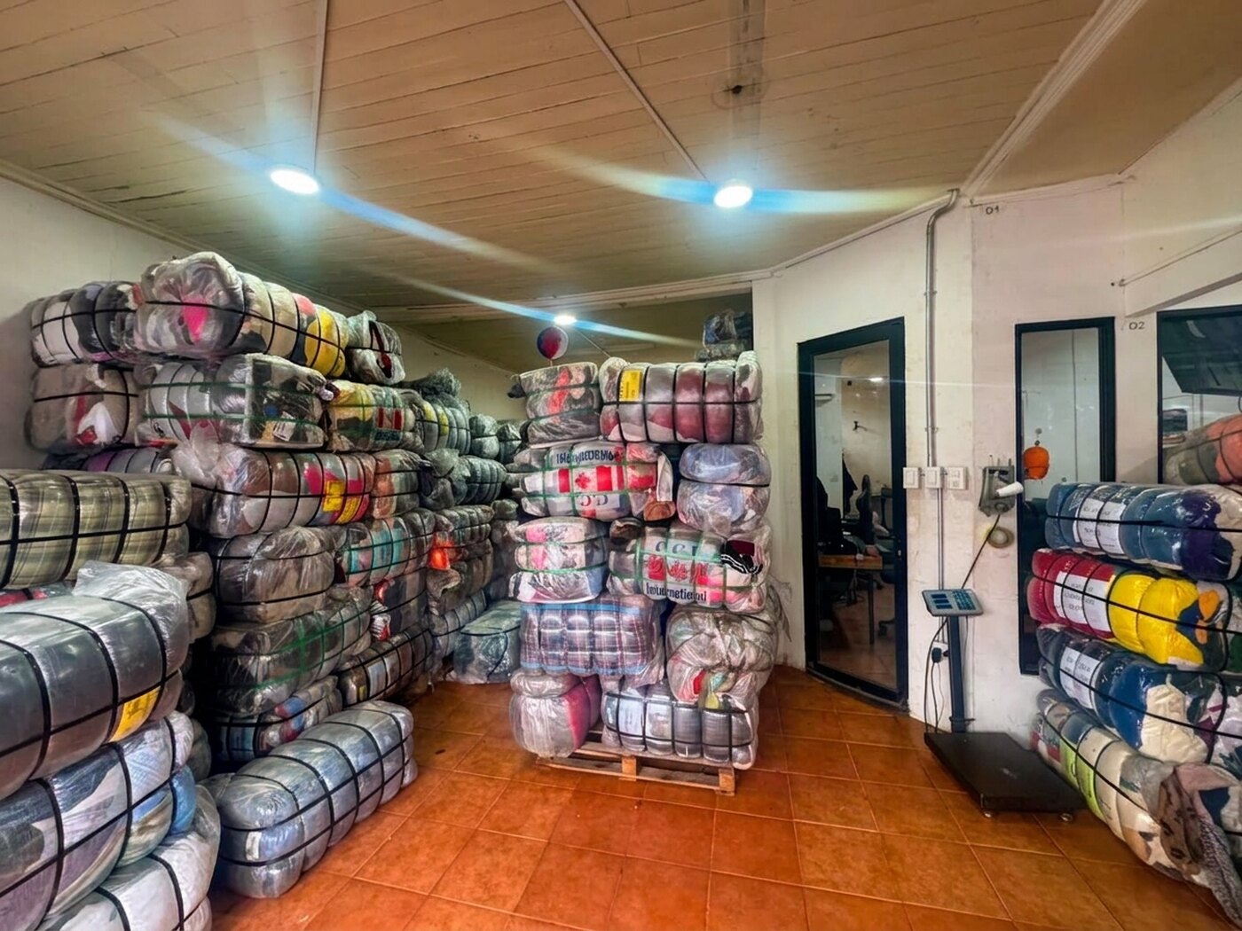 Bodega de Importadora Kansas en Talca con fardos de ropa americana apilados en pallets